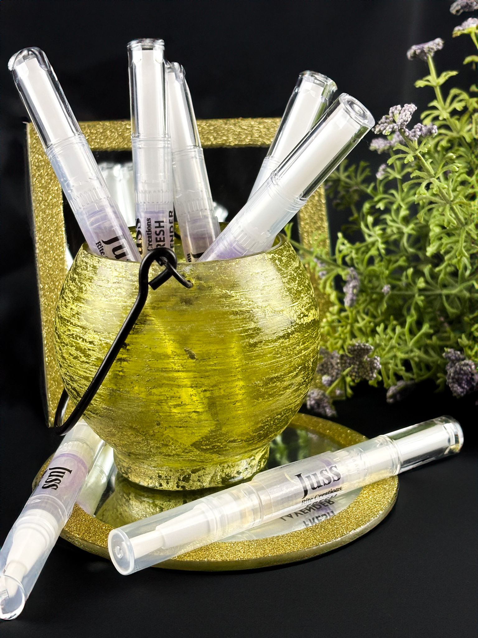 lavender cuticle oil pens with visible branding in a decorative holder on a dark background