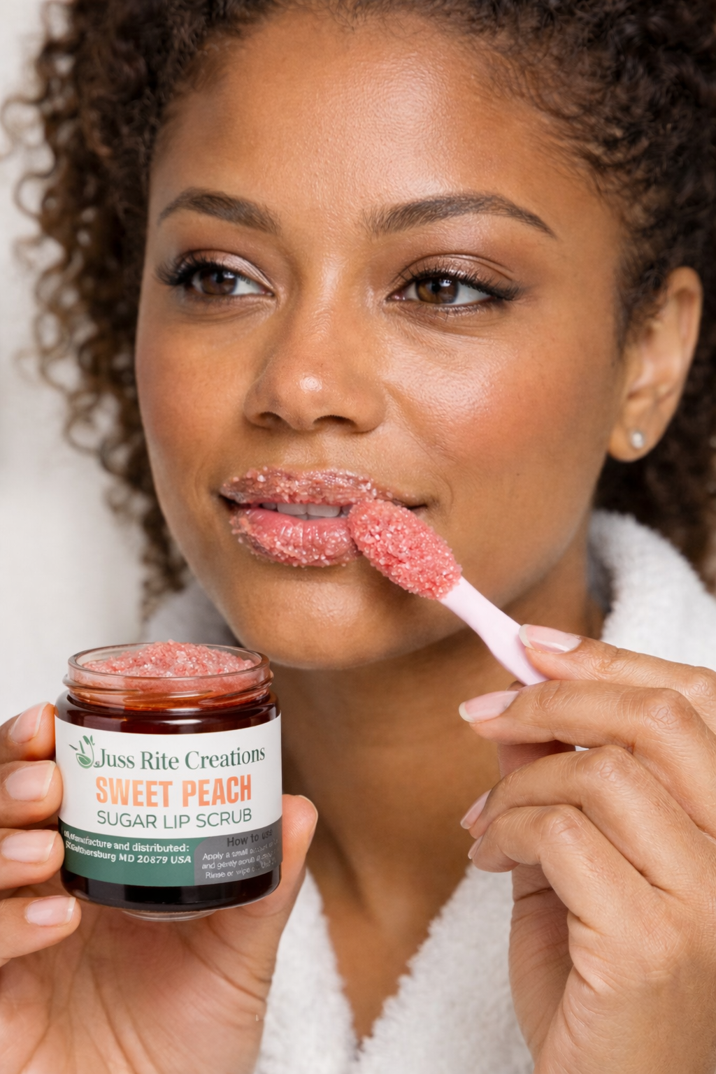 Woman applying a sugar lip scrub from Juss Rite Creations to her lips.