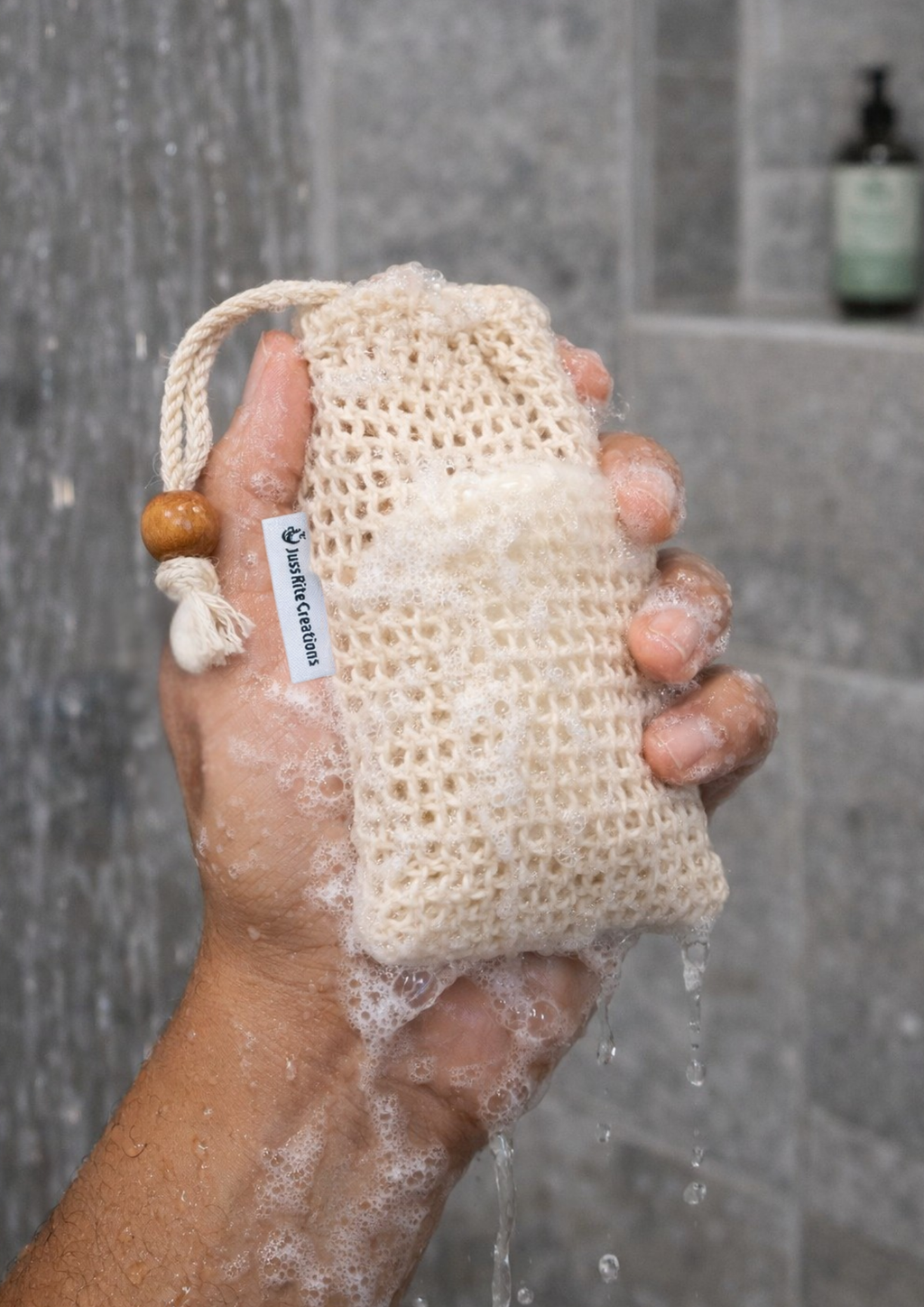 A person holding a Juss Rite Creations sisal soap bag with natural bar of soap inside