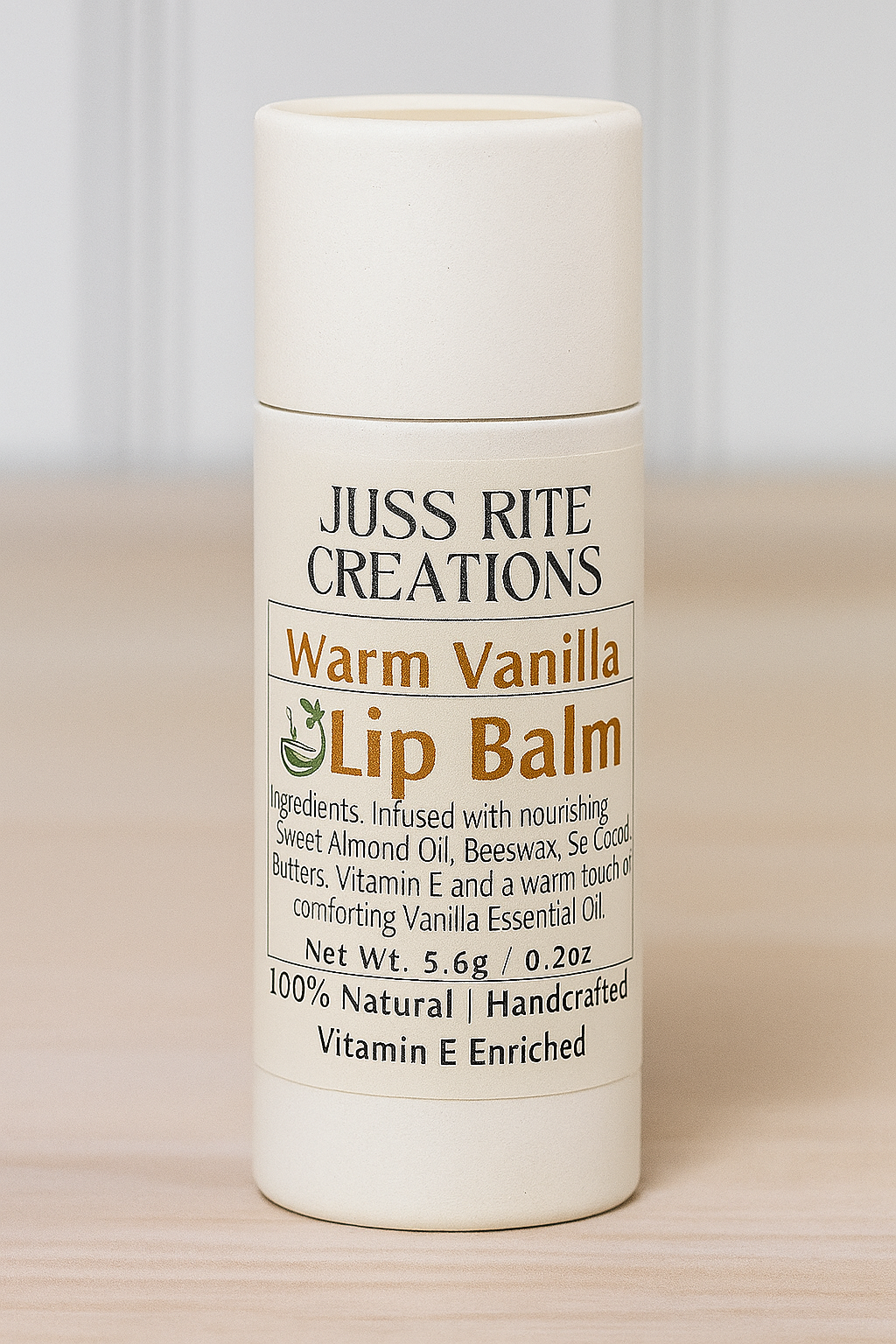 Lip balm container labeled 'Juss Rite Creations Warm Vanilla Lip Balm' on a wooden surface.