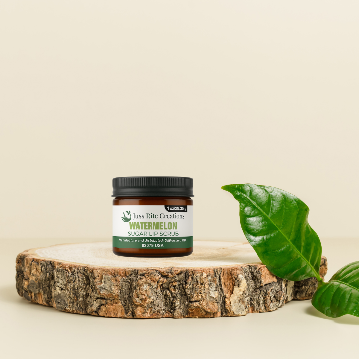 Jar of watermelon sugar lip scrub on a wooden platform with a green leaf on a beige background