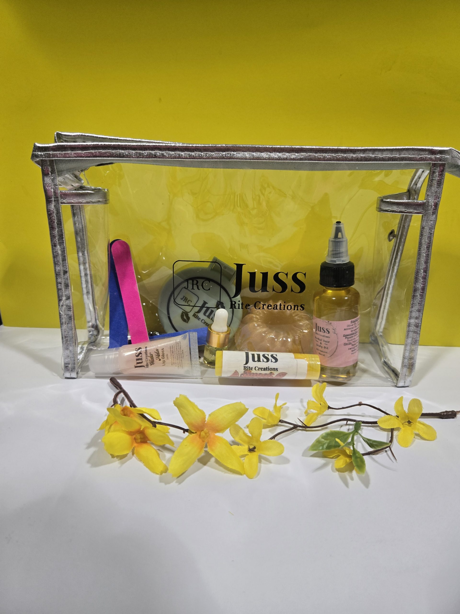 Clear cosmetic bag from Juss Rite Creations, showcasing travel-sized body care items.